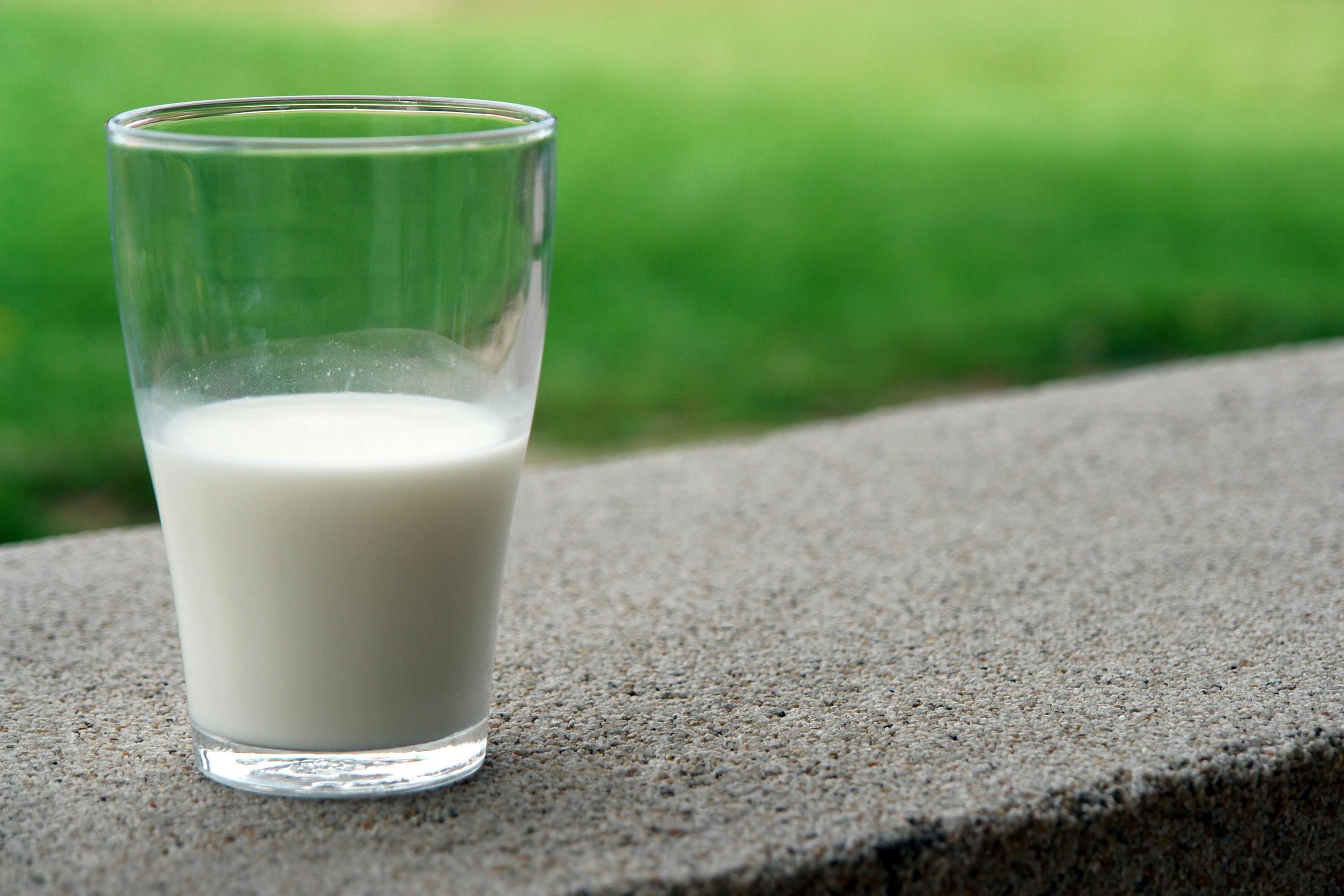 Glass bottles of milk on a wooden table